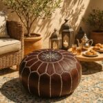 Dark brown leather round pouf with geometric stitching on an outdoor patio with Moroccan lanterns