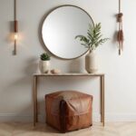 Square leather ottoman styled under console table with mirror, showing versatile entryway decor use