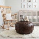 A cozy nursery setting with a Chocolate Brown Ottoman used as a center piece on a white sheepskin rug, featuring plush elephant and bear toys.