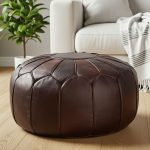 Chocolate Brown Ottoman on a wood floor next to a modern white sofa and a potted houseplant.