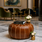 Round leather floor ottoman in elegant hotel lobby setting with fashion book and flowers on marble floor