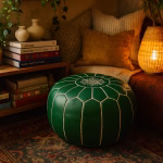 Cozy bohemian reading nook featuring a Leather Pouf Green, textured pillows, warm lighting, and a vintage rug.