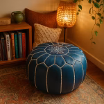 Cozy reading nook with a leather pouf blue, accented by warm lighting and woven textures.