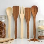 Complete lemon wood kitchenware 12" six piece utensil set arranged on white surface with storage jars