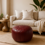 Deep Red Leather Pouf Round accenting a modern living room with beige sofa and neutral decor.