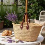 Straw tote bag with lavender and pastries on garden table - French market basket for outdoor dining