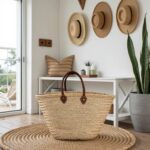 Natural herringbone weave straw tote bag with leather handles on round jute rug - boho market basket