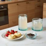 Close-up of aqua handblown wine glasses with sparkling water and lemon on wood