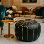 Handcrafted black leather floor ottoman with white stitching displayed in elegant living room with gold accent table