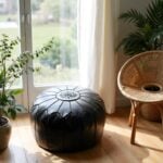 Black leather floor ottoman by window - scandinavian style round pouf with star stitching detail