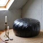 Black leather floor ottoman on jute rug - handcrafted round pouf with embossed star design and candles