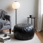 Black leather floor ottoman in minimalist living room - versatile round pouf for seating and footrest