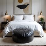 Black leather floor ottoman at foot of bed - elegant round pouf with hand-stitched star medallion