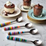 Handmade ceramic tea spoons with rainbow striped handles beside chocolate mousse desserts on elegant plates