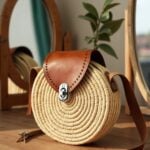 Round straw crossbody bag showing handwoven circular pattern and leather flap detail close-up
