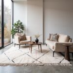 Cream Beni Ourain rug with artisan-woven diamond design in minimalist space with beige sectional and concrete floor