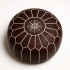 Dark brown leather floor ottoman with handcrafted star embroidery and geometric stitching detail