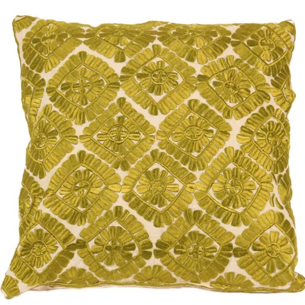 Terracotta geometric pillow covers with leather appliqué on beige reading chair, brass floor lamp