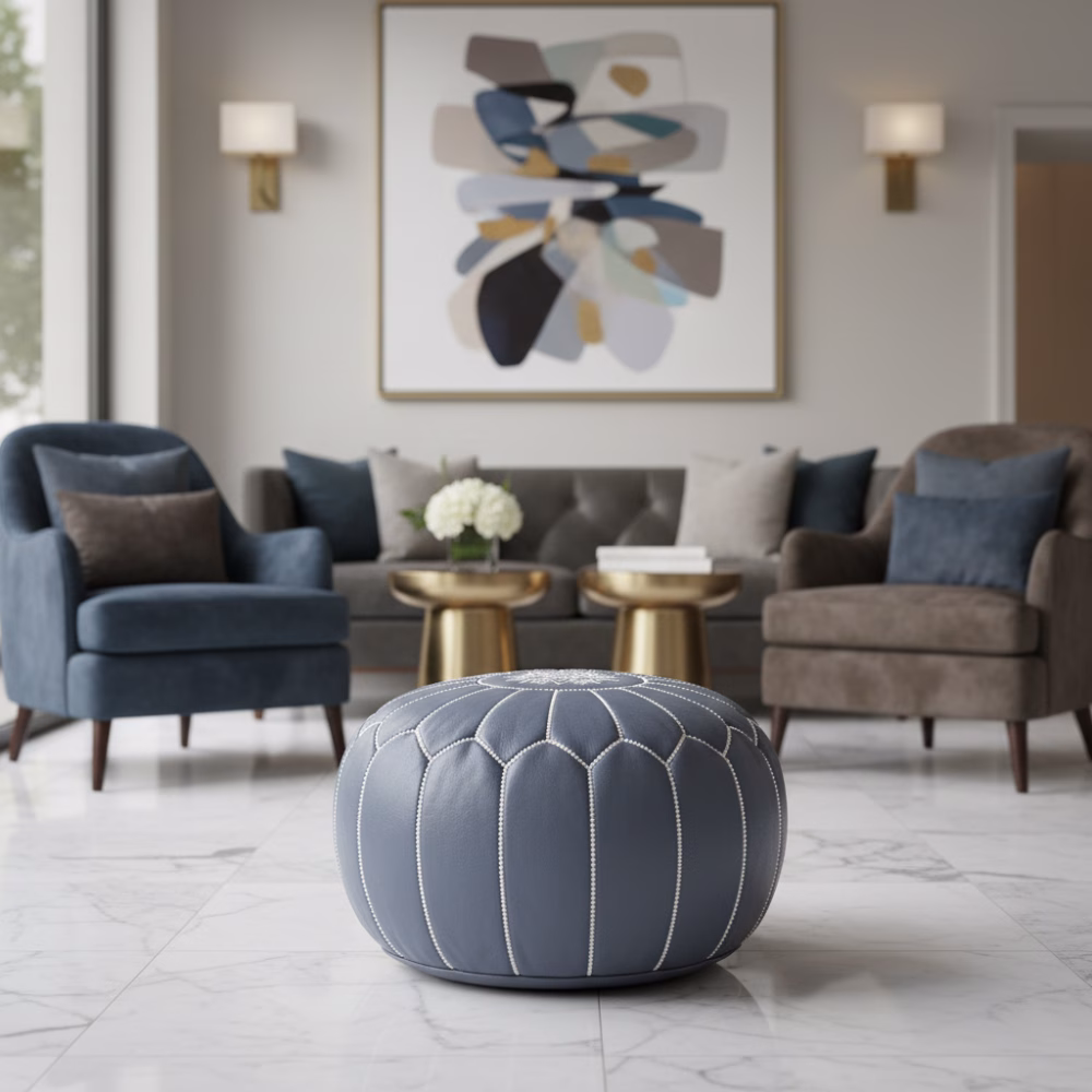 Leather Pouf Gray placed in an elegant living room with velvet chairs and marble flooring.