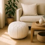 White leather round ottoman with geometric stitching in modern living room with beige sofa and natural light