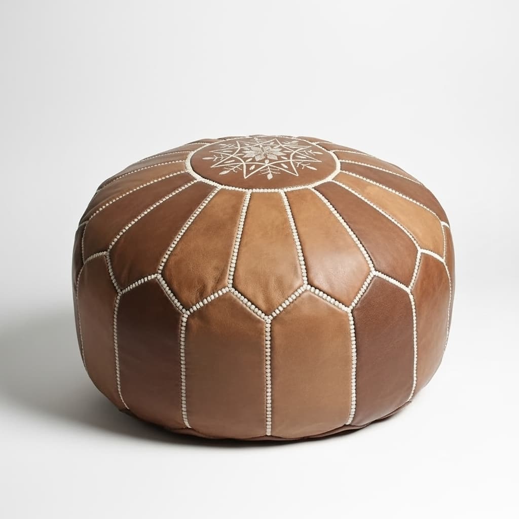 Leather Round Ottoman (4) Studio photo of the multi-toned brown Leather Round Ottoman with light embroidery on a white background.