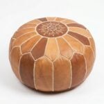 A handcrafted tan and brown Leather Round Ottoman featuring a traditional Moroccan star-stitched mandala design on a clean white background.