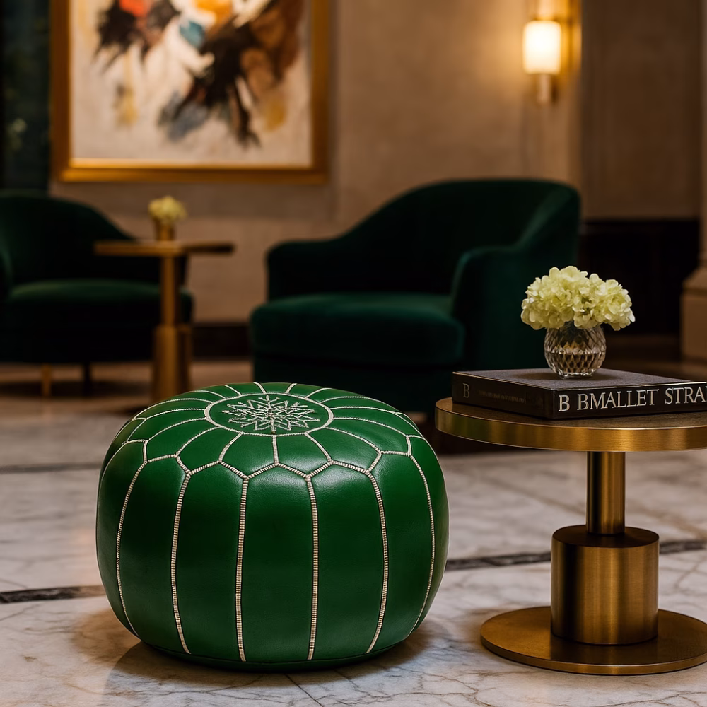 Luxurious hotel lobby setting with a Leather Pouf Green as a central decor piece beside velvet chairs and gold tables.