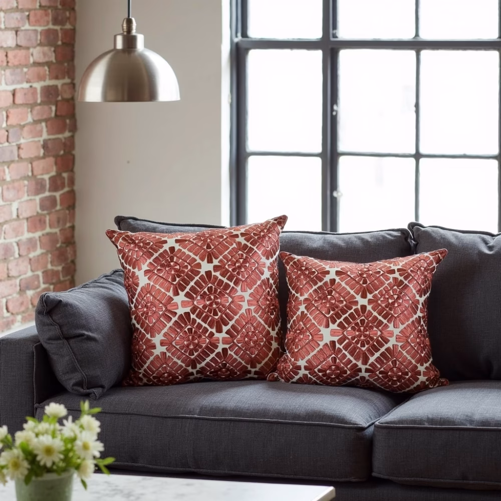 Embroidered pillow covers on dark gray sofa