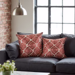 Embroidered pillow covers on dark gray sofa