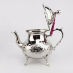Side view of hand-engraved silver teapot