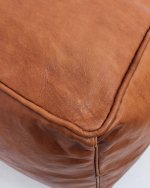 Close-up of square leather ottoman 16 inch showing premium cognac leather grain and corner stitching detail