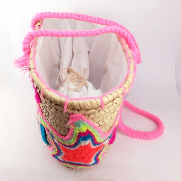Bright green straw basket bag with star embroidery on white background