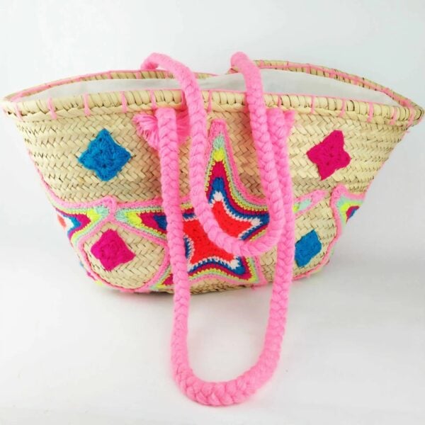 Pink embroidered straw bag with crocheted star motif, diamond appliqué and braided straps on handwoven palm leaf