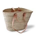 Handwoven Moroccan straw basket bag with double leather handles on white background