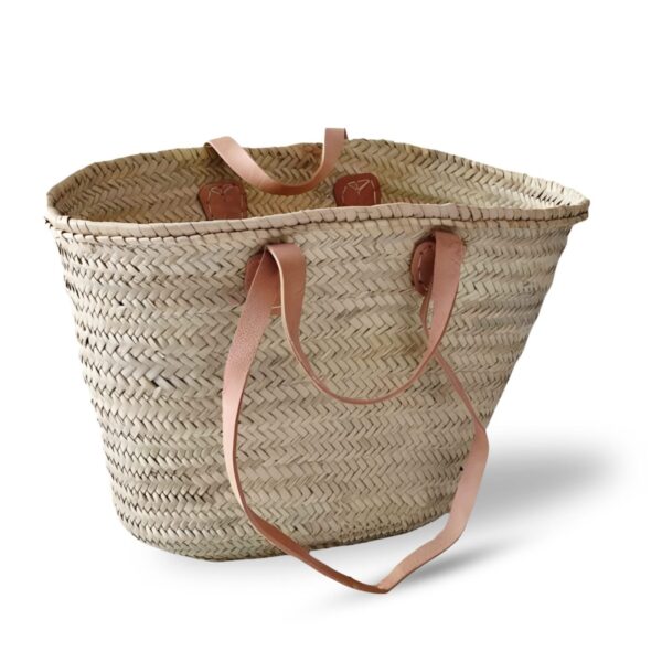 Handwoven Moroccan straw basket bag with double leather handles on white background