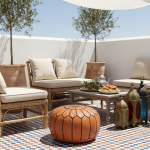 Natural leather pouf ottoman on a Moroccan terrace with traditional lanterns and mint tea service.