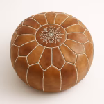 Overhead view of handcrafted natural leather pouf with white stitching