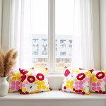 Colorful embroidered pillows styled in bright window setting