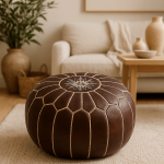 Handcrafted leather floor ottoman pouf in neutral living room with beige furniture and natural decor