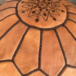 Close-up of brown stitching on natural leather pouf