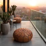 Tan leather round ottoman on balcony terrace at sunset with glass railing and city view