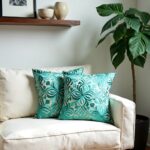 Teal floral pillow covers on cream sofa with tropical houseplant and minimalist decor
