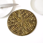 Single straw placemat styled as a charger beneath minimalist white crockery