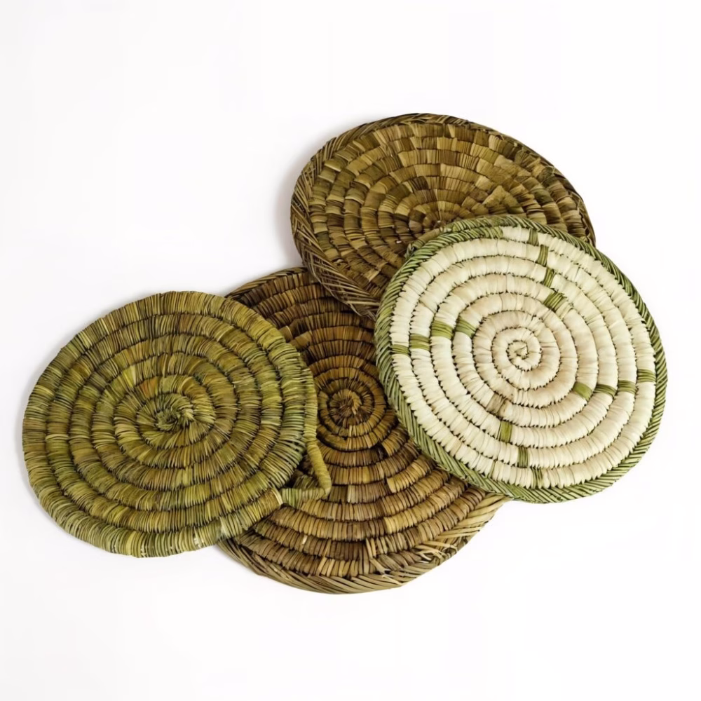 Stack of four round Moroccan straw placemats showing varied earthy shades