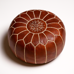 Studio shot of a leather pouf brown with detailed embroidery, highlighting the artisanal quality of Moroccan craftsmanship.