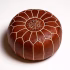 Studio shot of a leather pouf brown with detailed embroidery, highlighting the artisanal quality of Moroccan craftsmanship.