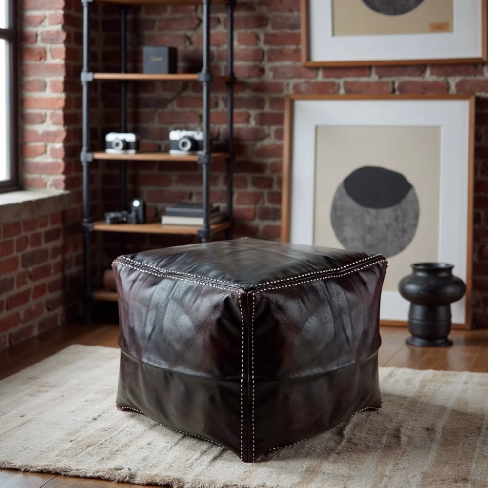 Square ottoman pouf against exposed brick wall