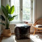 Square leather floor ottoman as footrest under modern white desk with laptop and orchid plant
