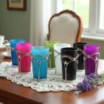 Jewel-tone colorful tea glasses in silver filigree holders on a lace cloth in a sunlit room