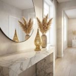Elegant brass bedside lamp lit on a marble console table, reflected in a round mirror alongside pampas grass decor.